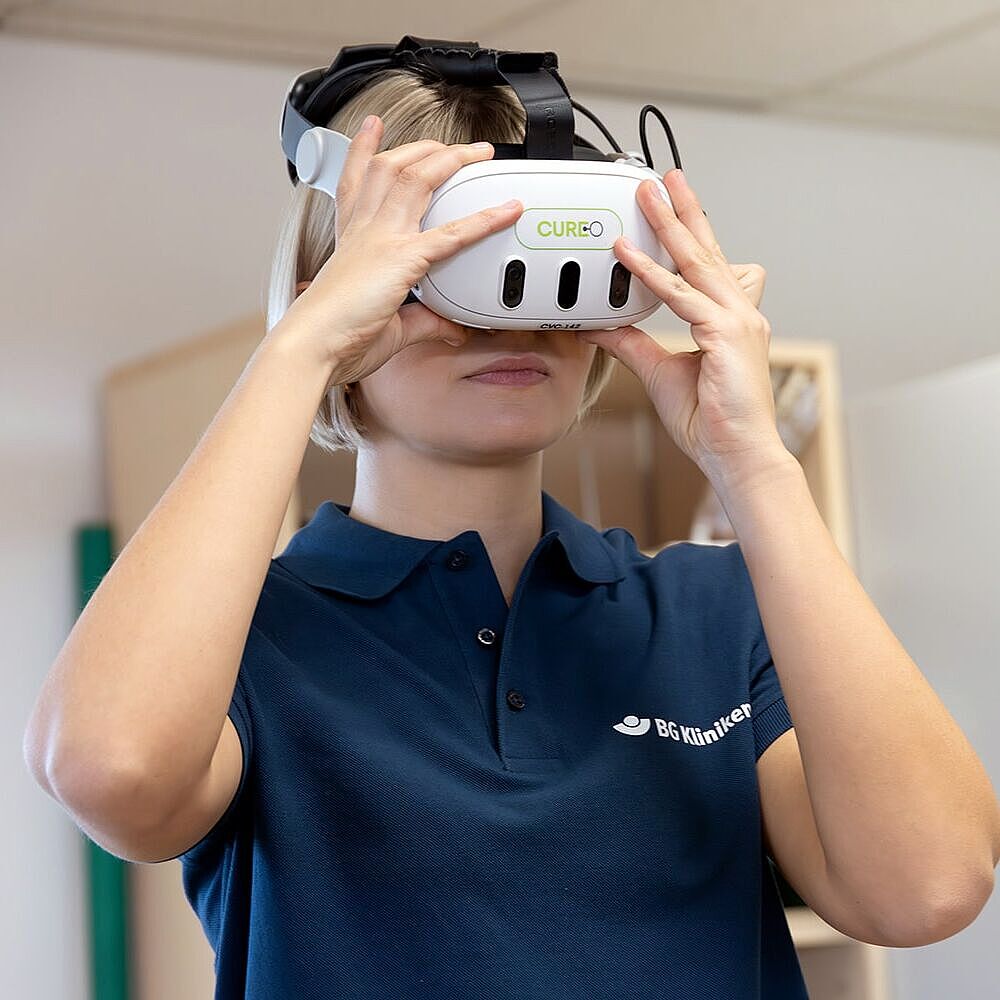 Einsatz von VR in der Rehabilitation Therapeutin beim Anprobieren der VR Brille